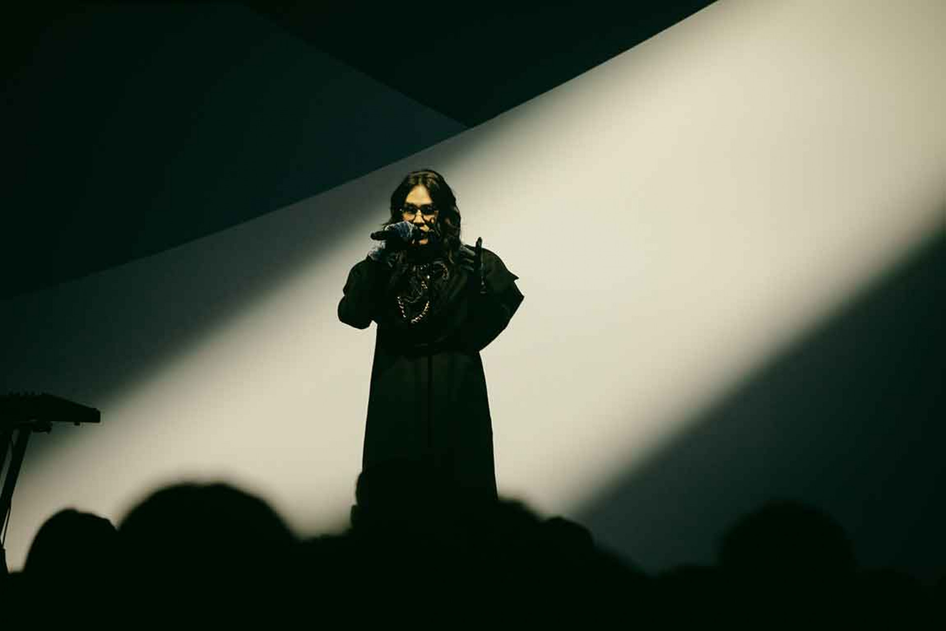 穿搭品味風格獨具的鶴-The-Crane,身著一席黑色寬肩外套與拼接長裙登場