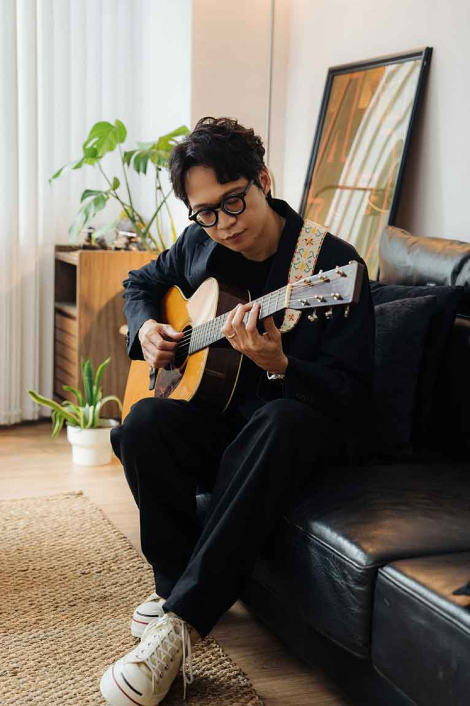 張淦勛帶著部落姑姑替他手工縫製的吉他背帶在身上